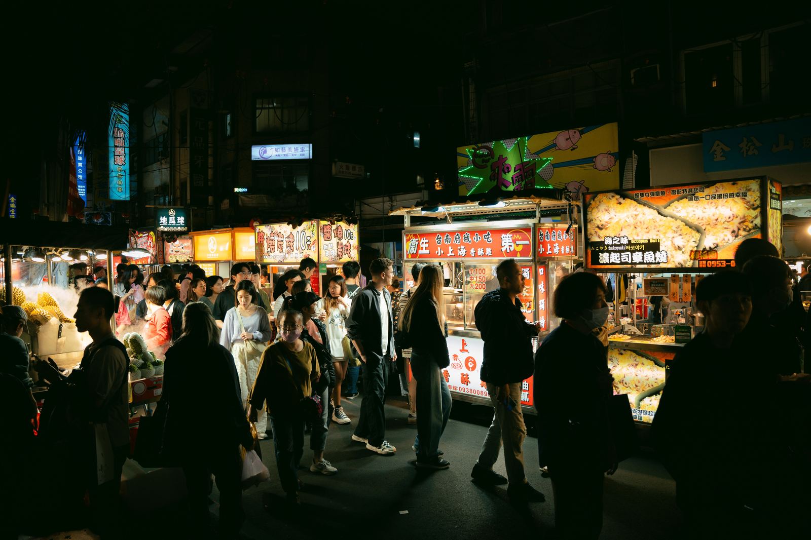A crowded street at a Taiwan night market after dark